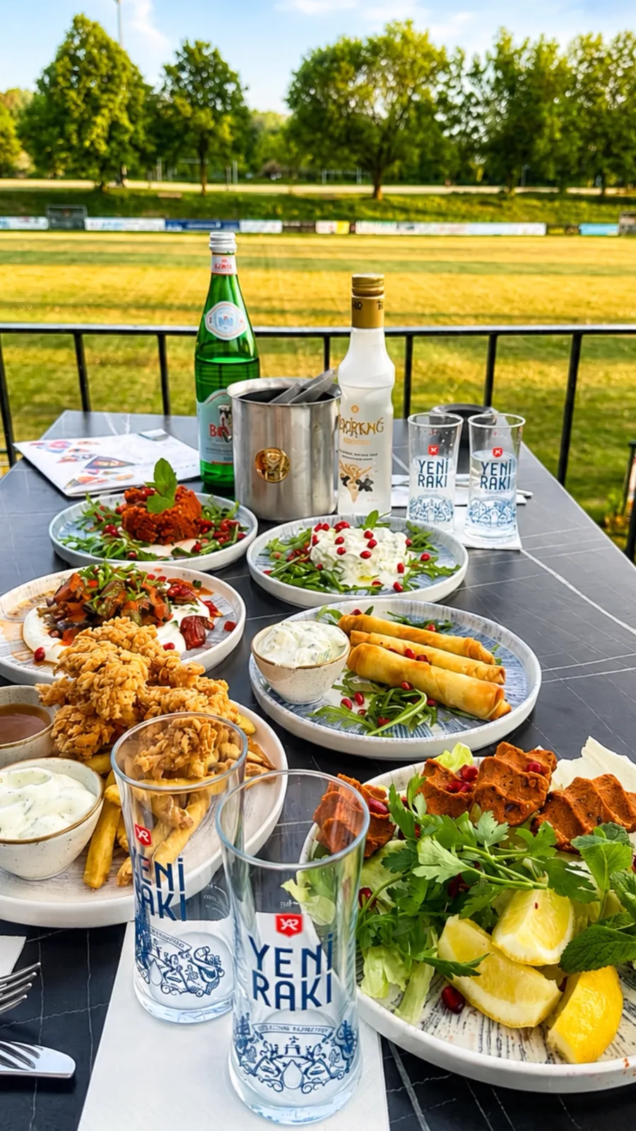 Gedeckter Tisch auf der Terrasse mit vielen Vorspeisen und Rakı-Gläsern